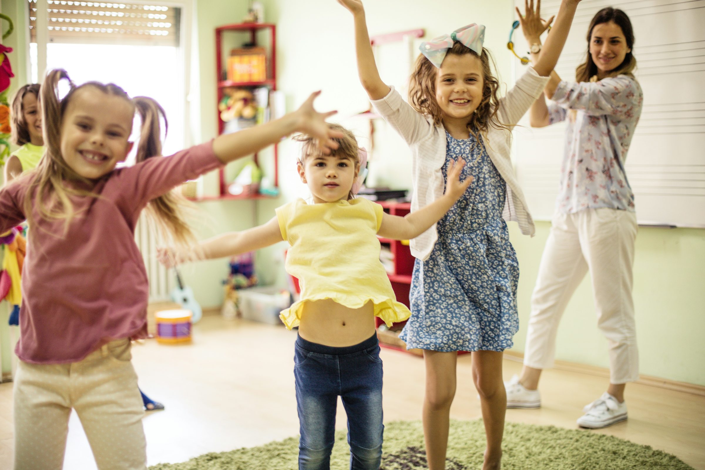 A teacher and elementary-age students dancing and moving together in a Lake Country Spanish class